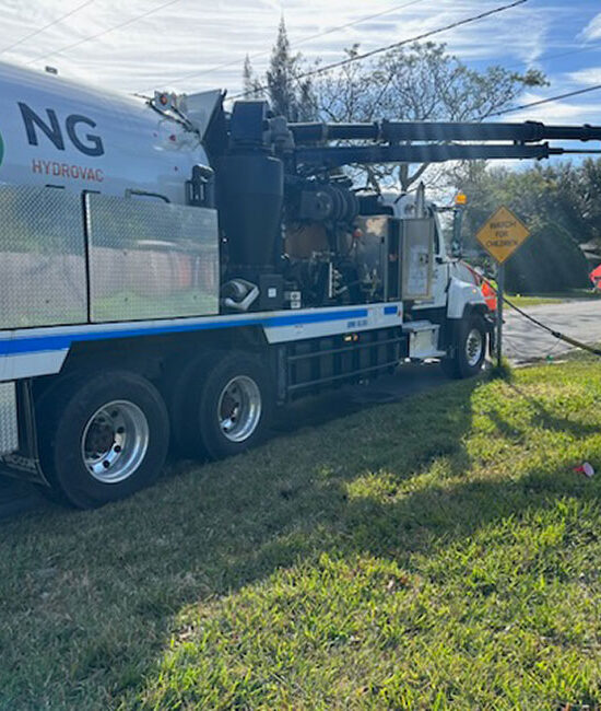 NG Companies hydrovac truck with employee using hydrovac in the grass